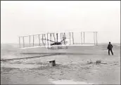  ?? JOHN T. DANIELS AP/LIBRARY OF CONGRESS ?? Orville Wright at the controls of the Wright Flyer on Dec. 17, 1903, at Kitty Hawk, N.C. Wilbur is at right.