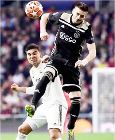  ??  ?? Real Madrid’s Brazilian midfielder Casemiro (left) vies for the ball with Ajax’s Serbian forward Dusan Tadic during the UEFA Champions League round of 16 second leg match at the Santiago Bernabeu stadium in Madrid. — AFP photo