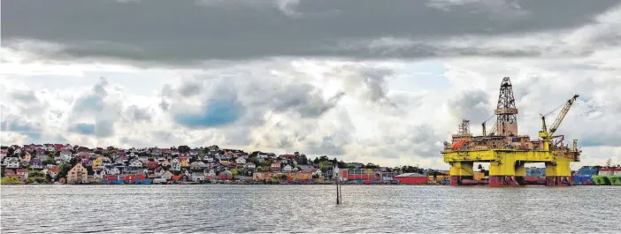  ?? FOTO: IMAGO IMAGES ?? Idylle mit Schönheits­fehler: Den Blick auf die Stadt Sandnes und ihren Hafen trübt eine Bohrinsel. Das in Norwegen geförderte Öl wird fast ausschließ­lich in andere Länder exportiert.