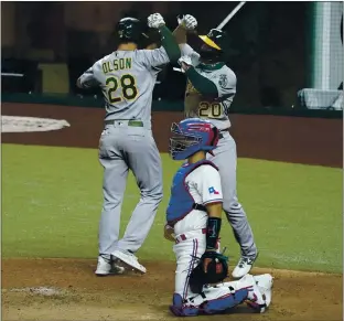  ?? TONY GUTIERREZ — THE ASSOCIATED PRESS ?? The Athletics’ Matt Olson, left, and Mark Canha celebrate Olson’s two-run homer against the Rangers.