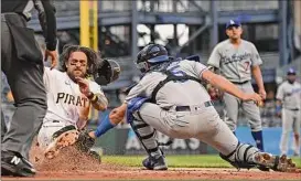  ?? Justin Berl / Getty Images ?? Pittsburgh’s Michael Chavis slides in ahead of the tag from Dodgers catcher Austin Barnes in the Pirates’ win over Los Angeles on Monday.