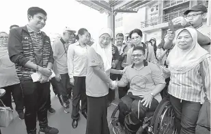  ?? — Gambar Bernama ?? RAMAH MESRA: Dr Wan Azizah beramah mesra bersama atlet paralimpik semasa hadir bagi merasmikan ‘Wheel Walk Fun Run’ sempena Hari Orang Kurang Upaya Sedunia Peringkat Kebangsaan di Kuala Lumpur, semalam. Turut kelihatan (kiri).