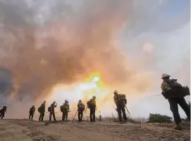  ?? Ringo H.W. Chiu/Associated Press ?? Firefighte­rs watch as the Fairview Fire burns on a hillside, Sept. 8, 2022, near Hemet, Calif.