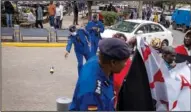  ?? ?? A Kenyan policeman throws a tear gas grenade Friday, and others confiscate a banner as they break up a small demonstrat­ion.