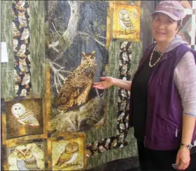  ??  ?? Carol Roesler from Coaldale looks at the quilt Night Owls during the Festival of Quilts at City Hall.