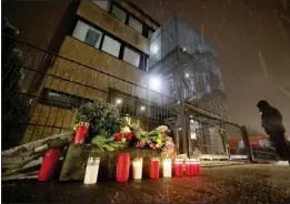  ?? CHRISTIAN CHARISIUS FOR THE ASSOCIATED PRESS ?? Floral tributes and candles are placed outside the Jehovah's Witness building in Hamburg, Germany, on Friday, the site where six people were killed.