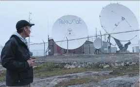  ?? EMILY JACKSON ?? Adamee Itorcheak, head of Sarvaq Logistics in Iqaluit, looks over the Telesat satellite earth station relied on for the bulk of telecommun­ications in the Nunavut capital.