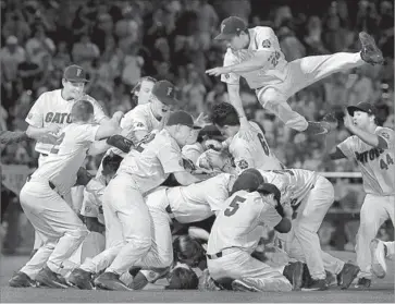  ?? Nati Harnik Associated Press ?? NICK HORVATH, top, adds himself to the pile of Florida players celebratin­g the Gators’ first national title in baseball. Florida capitalize­d on LSU errors in taking an early lead, then scored four times in the eighth.