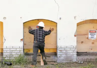  ?? Liz Hafalia / The Chronicle ?? Basement windows are boarded up at the officially vacant city-owned building on Miller Avenue in Oakland.