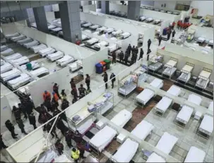  ??  ?? Above: Patients infected with the novel coronaviru­s begin arriving for treatment at the 1,600-bed hospital set up at the Wuhan Internatio­nal Conference and Exhibition Center in Wuhan, Hubei province, on Wednesday. YUAN ZHENG / FOR CHINA DAILY