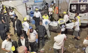  ?? Associated Press ?? AUTHORITIE­S carry the body of a victim of the stampede on Friday at Mt. Meron in Israel. An estimated 100,000 people had gathered for the Lag BaOmer celebratio­ns. The cause of the stampede was unclear.