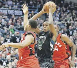  ?? AP PHoTo ?? Milwaukee Bucks’ Khris Middleton drives past Toronto Raptors’ Kyle Lowry and Norman Powell during the second half of Game 3 of their NBA firstround playoff series game Thursday in Milwaukee.