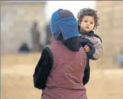  ?? AFP ?? A displaced Syrian woman with child in Deir Ezzor city