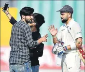  ??  ?? In a serious breach of security, fans invaded the pitch and took selfies with India captain Virat Kohli in Rajkot on Thursday.