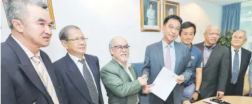  ??  ?? Liew presents details of the upcoming tournament­s to Karim (fourth right) while SLTA committee, events organising committee and Sports Unit head of the ministry Zul Usup (second right) look on.