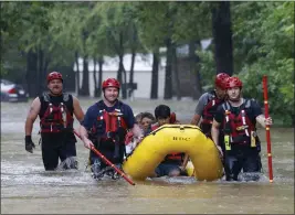  ?? EL’AS VALVERDE II — THE DALLAS MORNING NEWS ?? Members of the Balch Springs Fire Department bring a family of four by boat to higher ground after rescuing them from their home along Forest Glen Lane in Batch Springs, Texas, on Monday.