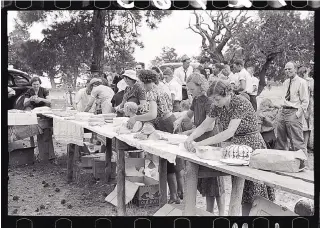  ?? COURTESY OF RUSSELL LEE VIA THE LIBRARY OF CONGRESS ?? Pie Town locals gather for a potluck during an all-day community sing in June of 1940. The ladies are setting out baked goods.