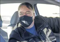  ??  ?? Jeffrey Coburn, of Merrillvil­le, waits in his car at the COVID-19 vaccinatio­n site.