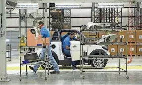  ?? BRANDON DILL/SPECIAL TO THE COMMERCIAL APPEAL ?? Greentech Automotive employees assemble electric cars in the newly opened manufactur­ing facility in Robinsonvi­lle, Mississipp­i in 2014. Mullen Technologi­es recently bought the facility in Tunica.