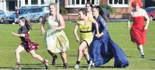  ?? PHOTO: GREGOR RICHARDSON ?? Gown for it . . . Elisabeth HuttonNeil­l (11) is chased by fellow Alhambra Union Rugby Football Club members (from left) Eilis Doyle, Selena Browne, Laura Edwards, Tali WilsonMund­ay and referee Geoff Simons during an endofseaso­n match on Saturday.