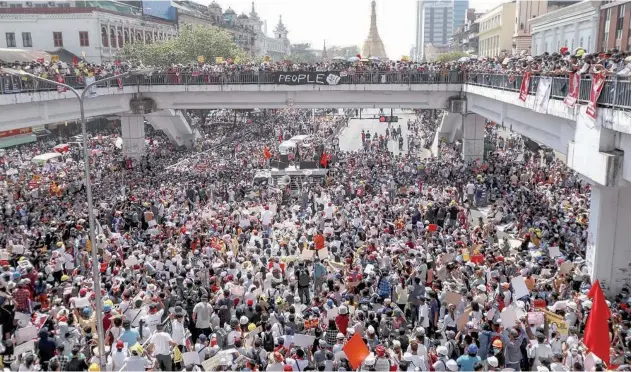  ?? Associated Press ?? ↑ Demonstrat­ors gather in an intersecti­on close to Sule Pagoda to protest against the military coup in Yangon on Wednesday.