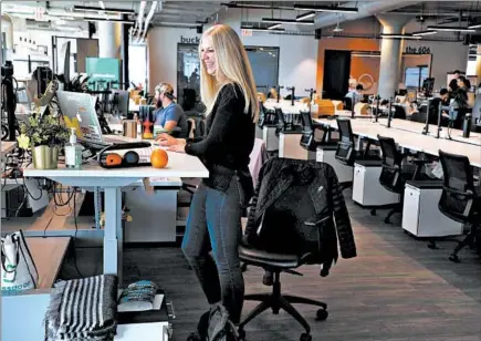  ?? TERRENCE ANTONIO JAMES/CHICAGO TRIBUNE ?? Glassdoor recruiter Brianna Kelly uses her standing workstatio­n at the company’s Chicago office on March 28. Glassdoor, a jobs recruiting and review website based in San Francisco, is expanding its Chicago office in Fulton Market. Chicago notched gains in tech employment in 2019.