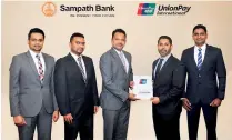  ?? ?? Darshin Pathinayak­e, Assistant General Manager - Card Center, Sampath Bank PLC (3rd from left) exchanging the MoU with Crispin Wijesekera, Country Manager - Sri Lanka & Maldives, UnionPay Internatio­nal.
Others in the image – From left –Chirath Samaraseka­ra, Manager - Card Promotions, Loyalty & Product Strategy, Card Centre, Sampath Bank; Buddhika Amunugama, Manager - Card Portfolio, Sales & Merchant Relationsh­ips, Card Centre, Sampath Bank; and Benzy Fernando, Head of Products and Business Developmen­t - Sri Lanka & Maldives, UnionPay Internatio­nal.