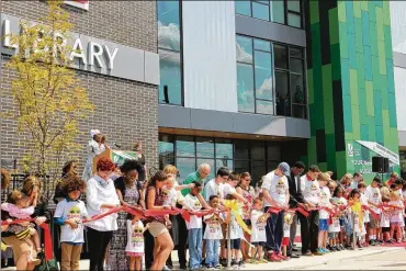  ?? CELIA LAVOIE / STAFF ?? Thousands in the community helped Dayton Metro Library celebrate the grand opening of the main branch, 215 E. Third St. on Saturday. The ribbon cutting stretched for an entire city block.