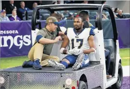  ?? Jim Mone Associated Press ?? RECEIVER Robert Woods is carted off the field after injuring his shoulder during the second half against Minnesota. Woods caught eight passes for 81 yards.