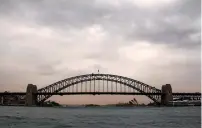  ?? Reuters ?? The Sydney Harbour Bridge and Sydney Opera House can be seen during a dust storm as it in descends upon the city of Sydney in Australia on Thursday. —