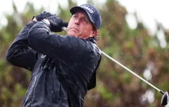  ?? PETER MORRISON/THE ASSOCIATED PRESS ?? A rain-soaked Phil Mickelson tees off at the 13th during second-round play at a wet and windy British Open Friday.