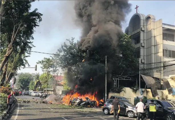  ?? ANDY PINARIA / GETTY IMAGES / SURABAYA GOVERNMENT HANDOUT ?? Flames pour out of the Surabaya Pantekosta Centre Church, the scene of one of three bomb blasts which targeted churches in Indonesia’s second-largest city on Sunday. At least 13 people were killed, including the bombers themselves.