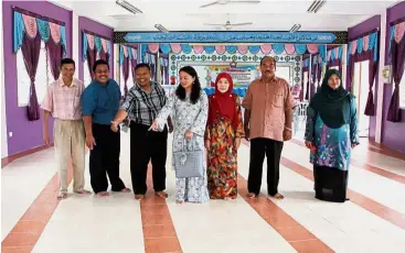  ??  ?? Looking good and comfortabl­e: Sekolah Rendah Agama Subang Mewah headmaster Husaini Selamat (third from left) and Yeoh (centre) looking at the completed hall floor after it had been tiled during a visit to the school.