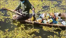  ?? Mukhtar Khan / Associated Press ?? A Kashmiri boatman removes garbage from the Dal Lake in Srinagar, Indian controlled Kashmir, on Sept. 14, 2021.