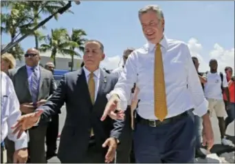  ?? ALAN DIAZ - THE ASSOCIATED PRESS ?? New York City Mayor Bill de Blasio, right, and Miami Beach Mayor Philip Levine, left, talk during a tour where the city has raised streets and installed pumps to combat rising tides, Friday, in Miami Beach, Fla. The U.S. Conference of Mayors opens its...