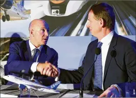  ?? PAUL CHIASSON / CANADIAN PRESS ?? Bombardier CEO Alain Bellemare (left) shakes hands Monday with Romain Trapp, North American CEO for Airbus Helicopter­s, at a Montreal press conference to announce Airbus’ buying of a majority stake in Bombardier’s Series C assets.