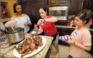  ?? NWA Democrat-Gazette/ANDY SHUPE ?? Internatio­nal students Elizabeth Kamarade of Rwanda (from left), Sarah Mohammad of Iraq and Sima Niro of Afghanista­n take part in an Independen­ce Day party hosted by Jhonnie and Bob Taylor of Fayettevil­le. The Spring Internatio­nal Language Center paired internatio­nal Fulbright scholars and Mexican teachers with Northwest Arkansas residents to celebrate the holiday.