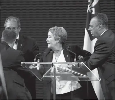  ?? GRAHAM HUGHES / THE CANADIAN PRESS ?? Quebec Premier Pauline Marois is removed from the stage by officers as she speaks in Montreal in September.