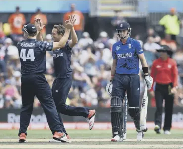  ?? PICTURE: SHAUN BOTTERILL/GETTY ?? 0 Josh Davey, centre, celebrates with Richie Berrington after dismissing England’s Joe Root in the clash between the sides in Christchur­ch at the 2015 Cricket World Cup.