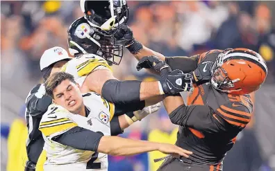  ?? DAVID RICHARD/ASSOCIATED PRESS ?? Cleveland’s Myles Garrett hits Pittsburgh quarterbac­k Mason Rudolph (2) with Rudolph’s helmet late in the fourth quarter of the Browns’ win over the Steelers Thursday.