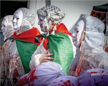  ?? UNENDING PLIGHT
AFP ?? Masked protesters in Rotterdam on Sunday take part in the ‘Hands off Rafah’ demonstrat­ion calling for a ceasefire in the war-devastated Gaza Strip.