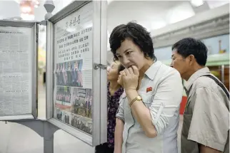  ??  ?? COMMUTERS read the latest edition of the Rodong Sinmun newspaper showing images of North Korean leader Kim Jong Un meeting with US President Donald Trump during their June 12 summit in Singapore, at a news stand on a subway platform of the Pyongyang...