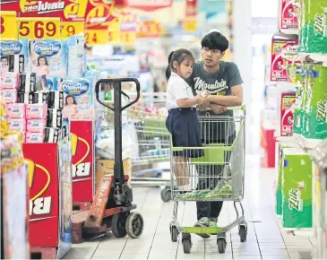  ?? PATIPAT JANTHONG ?? A customer pulls his shopping cart at a discount store chain in Bangkok.