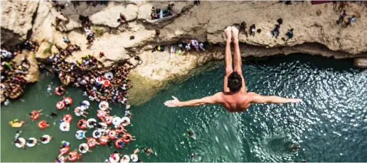  ??  ?? FLIGHT OF FANCY: Blake Aldridge leaps for glory during the Red Bull cliff-diving world series event at Wadi Shab, Oman