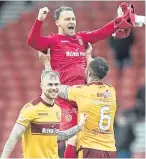  ?? Picture: Getty. ?? Motherwell keeper Trevor Carson celebrates with team-mate Peter Hartley at full-time.