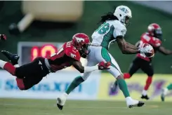  ?? JEFF MCINTOSH/ THE CANADIAN PRESS ?? Saskatchew­an’s Taj Smith, right, makes a fingertip catch in the second half as Calgary’s Demetrice Morley grabs him.