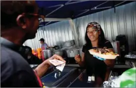  ??  ?? Josephine Peant selger streetfood til Patrick Vernen. Hun blir glad for å treffe mannen som har kjempet hardt for Windrush-generasjon­en.