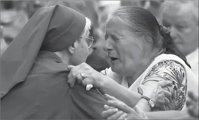  ??  ?? French nun greets a resident Thursday during a gathering in a town park for a solemn homage to the Rev. Jacques Hamel in SaintEtien­ne-du-Rouvray, Normandy, France.