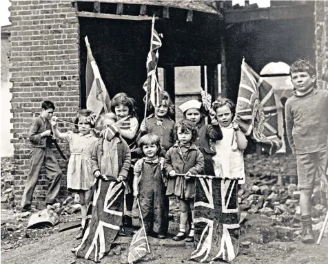  ??  ?? Flag day: children wave Union Flags in bomb-scarred Battersea, south London, on May 8 1945; boys wait for a sweet shop to open after the end of sweet rationing, below; St Paul’s Cathedral, London, at the end of the war, bottom