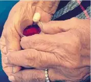  ?? ?? The writer’s mum prayerfull­y holds a communion cup as she awaits the Catholic practice of partaking holy communion. — SHEELA Kanagasaba­i